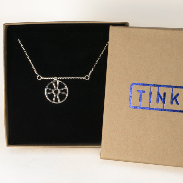 Moving Life Preserver on a Rope Necklace in a Tinker gift box, the pendant is an outline of a ring buoy that moves across a twisted wire rope. From a collection of kinetic jewelry and playful nautical necklaces.