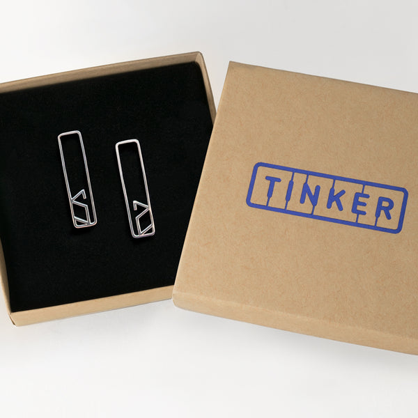 A pair of Alphabet Stud Earrings in the letter S shown inside a Tinker Company gift box.