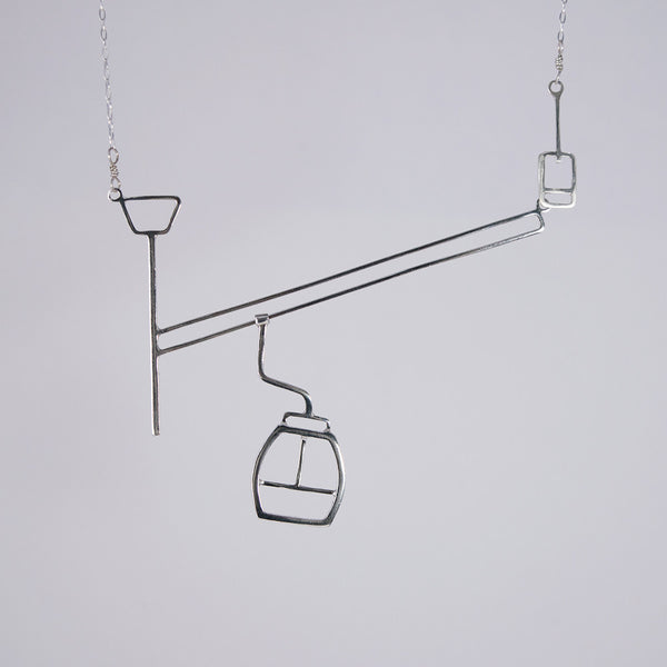 Ski lift necklace with moving gondola on a cable