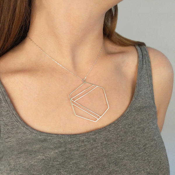 Sterling silver necklace with hexagonal shape outline and center stripe design, shown here on model