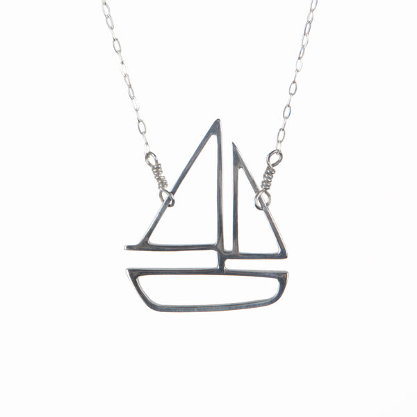 Silver sailboat charm pendant necklace from a collection of storytelling memory jewelry made in New York City by Tinker Company.