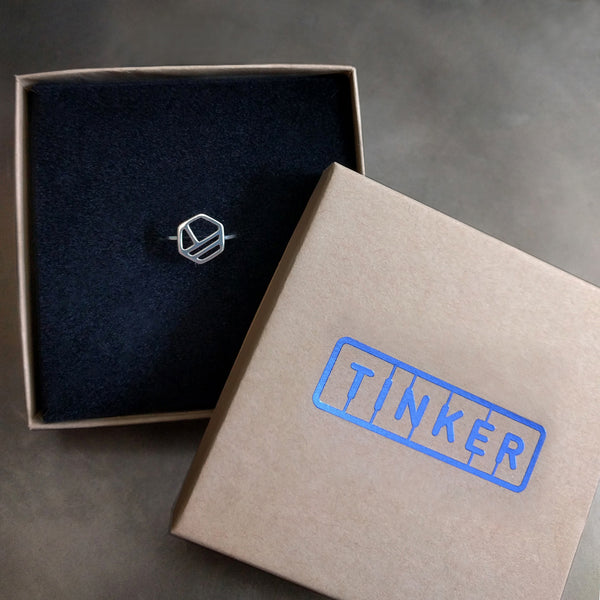 Silver Hexagon Ring with Three Lines, from a collection of minimalist geometric jewelry by Tinker Company. Shown in a Tinker gift box.