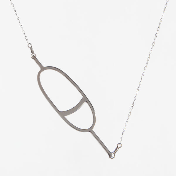 This sterling silver Nautical Buoy Pendant necklace has an outline of an oval buoy with a stripe, part of a collection of fun and playful nautical jewelry made in New York City by Tinker Company.