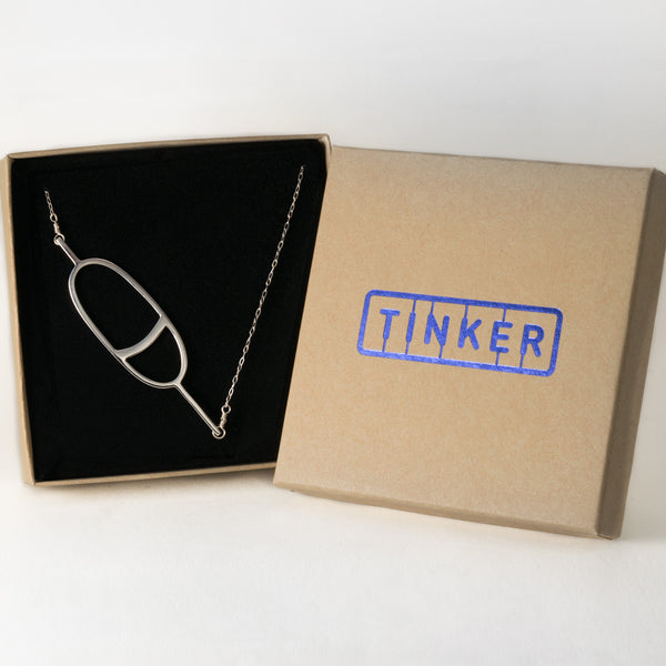 Oval Nautical Buoy Pendant with Stripe in solid sterling silver, shown in a Tinker Company gift box. From a collection of fun and playful nautical jewelry inspired by your favorite memories of summer spent on the water.