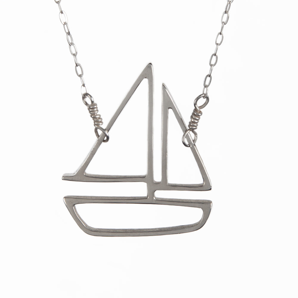 Silver sailboat charm pendant necklace from a collection of playful nautical jewelry made in New York City by Tinker Company.
