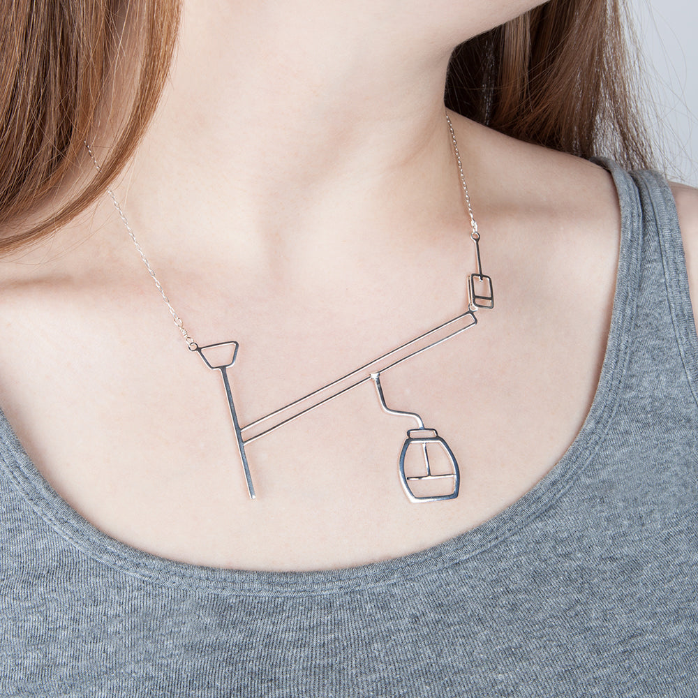 Ski Gondola necklace by Tinker Company shown on model.