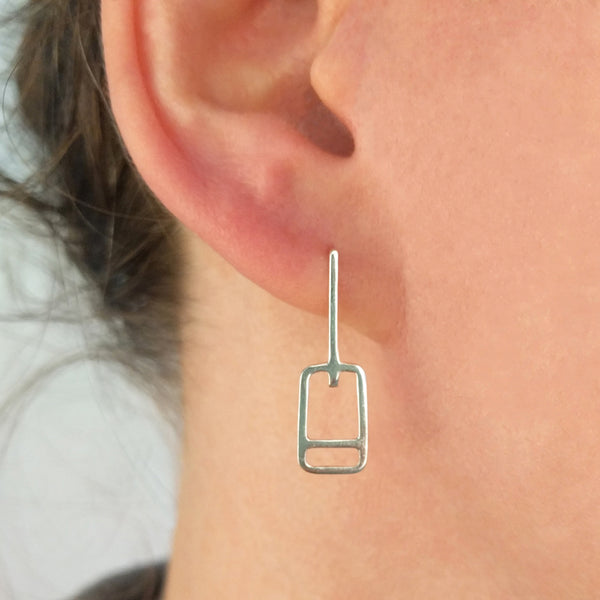 Tinker Company Lift Ticket Earrings as shown on a model's ear. Minimal geometric design made in sterling silver.