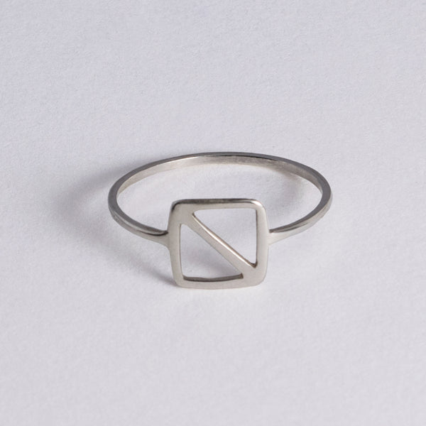 Silver ring inspired by the nautical flag for the letter "O" the maritime signal for "man overboard!" The minimal design is a square with a diagonal line from corner to corner.