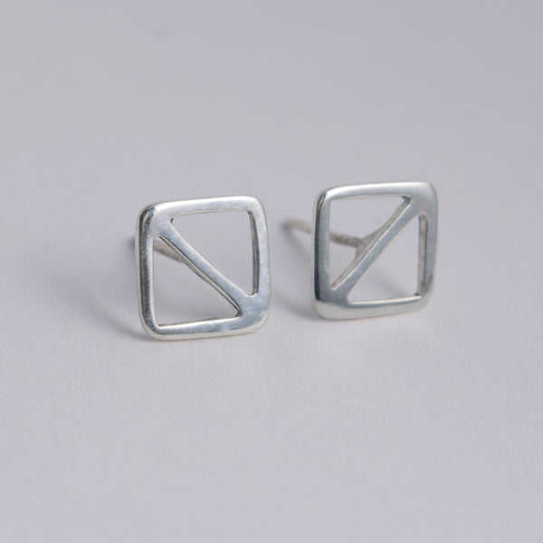 A facing pair of geometric nautical earrings in a square shape with a diagonal line. Inspired by the letter O nautical flag. Sustainably made in New York City by Tinker Company.