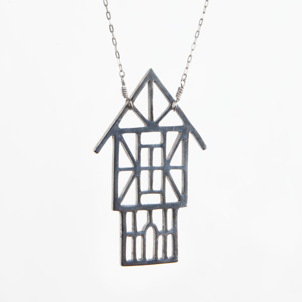 Angled view of the Tudor Ski Chalet Necklace in solid sterling silver. Architectural jewelry designed and made in NYC by Tinker Company.