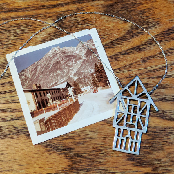 Tudor Ski Chalet Necklace with a vintage photo of a snow-topped mountain in a European ski village. Capture your winter vacation memories with Tinker jewelry.
